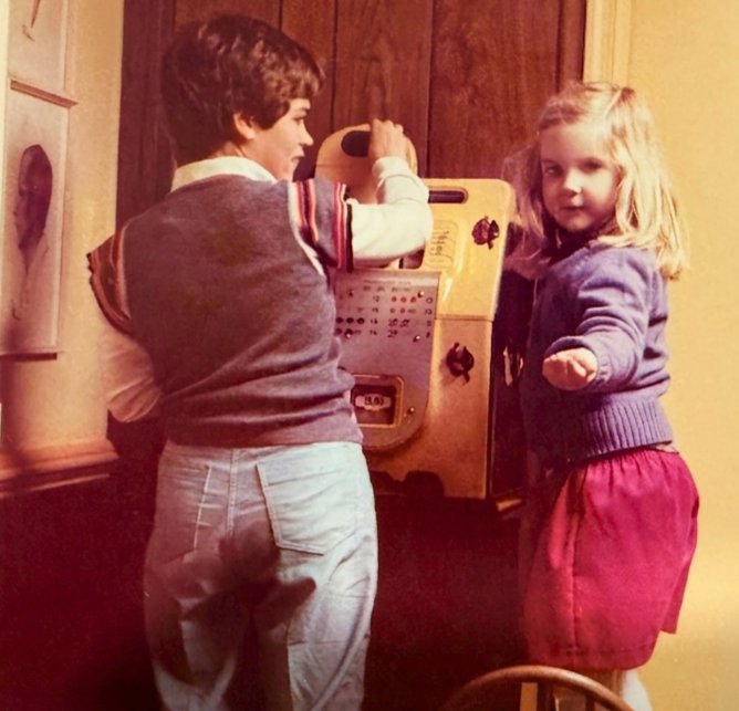 Young Angie standing on a chair in 1982, alongside her older cousin Susan